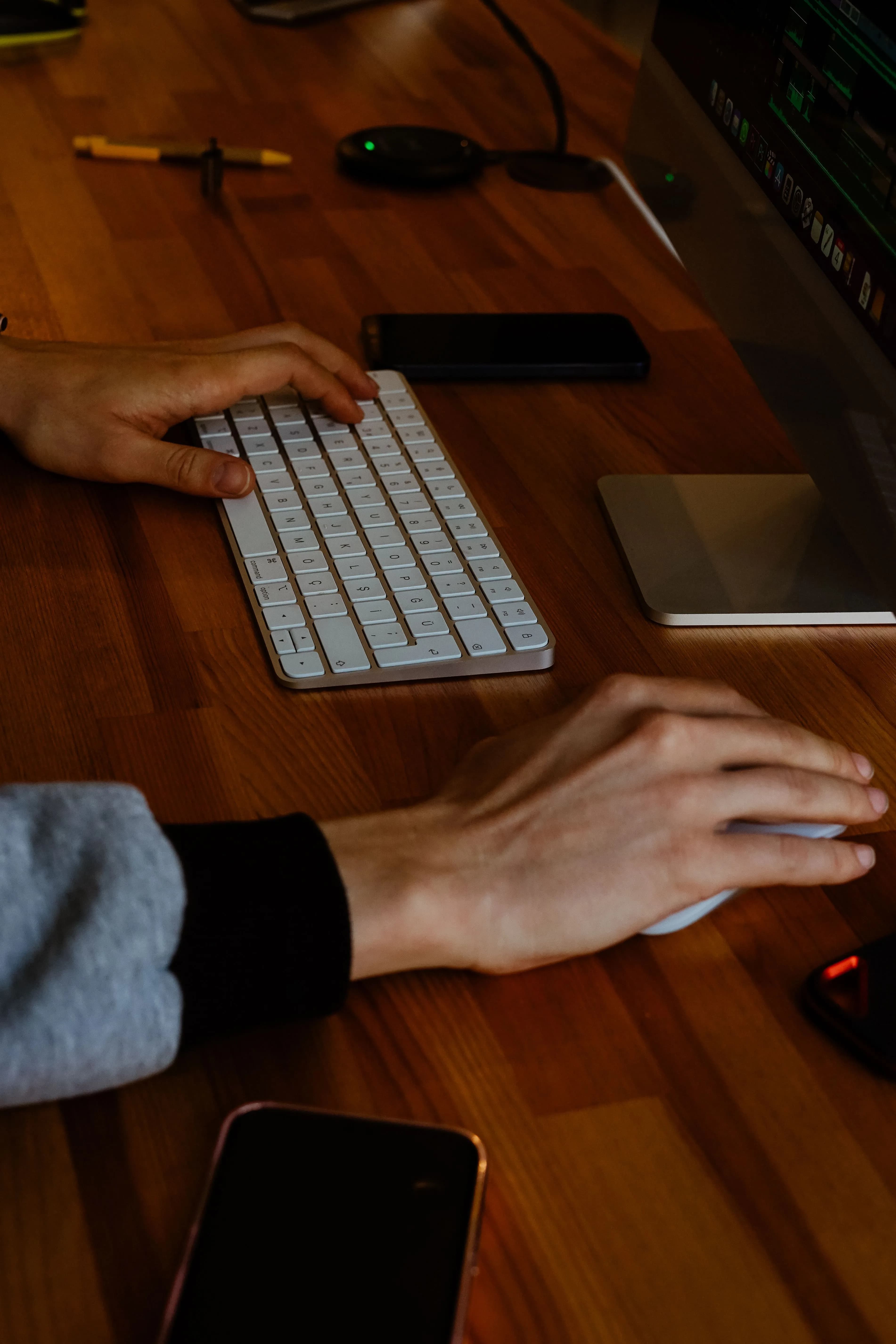 A desktop workstation by a window, its display showing a mountain landscape
